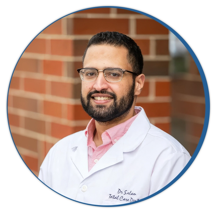 Dentist Hossam Abdelsalam Smiling In Front Of Brick Wall Circle Cutout