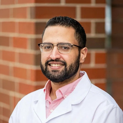 Dentist Hossam Abdelsalam Smiling In Front Of Brick Wall